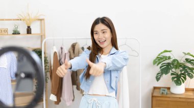 Sosyal medya etkisine sahip güzel bir kadın, seyirciyi video canlı yayını, çevrimiçi moda giyim sektörü, müşterilere ilgi göstermek için psikolojiyi kullandıkları için selamlıyor..