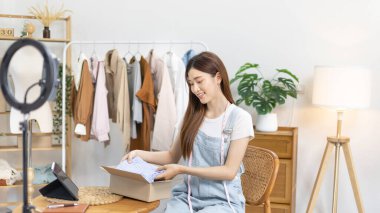 Kadın posta kutusunu paketleyip müşteriye teslim etmeye hazırlanıyor, evde çalışıyor ve işletme sahibi oluyor, çevrimiçi alışveriş yapan KOBİ girişimcisi, paketleme kutusu, çevrimiçi satış, serbest çalışma.