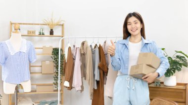 Sosyal medya etkisine sahip güzel bir kadın, video görüntülerini canlı yayınladıkları için seyirciyi selamlıyor, canlı yayın sırasında posta kutusunu kaldırıp müşterinin siparişini onaylıyor, Online moda işi..