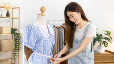 Professional female designers use a tape measure around the shirt in the studio, Fashion designer, Creativity and ideas, Mannequin, Shirt sketch, Color scheme, Garment accessories.