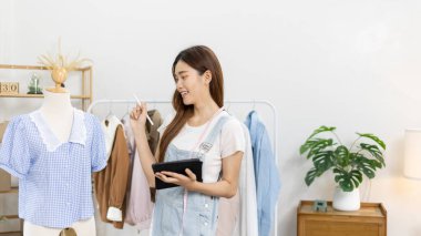 Tasarım stüdyosundaki tablet, moda tasarımcısı, yaratıcılık ve fikirler, manken, tişört çizimi, renk düzeni, giysi aksesuarları aracılığıyla profesyonel kadın tasarımcı kıyafetleri tasvir etme, bağımsız çalışma.