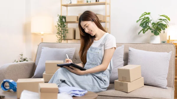 stock image Woman uses mobile phone or tablet to chat with customers who come to order product, Freelance work at home, Conversation with customers through massage, Small business owner, SME entrepreneur.