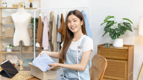 Woman is packing in the mailbox to prepare to deliver it to the customer, Working at home and owning businesses, Online shopping SME entrepreneur, Packing box, Sell online, Freelance working.