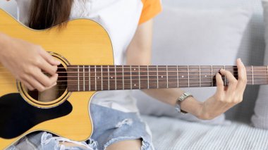 Gitar telleri çalan parmakları kapat, gitar çalmak için Strum, akustik gitar, müzik yapmak için gitar akorları yakalamak, müzik terapisi ve gitar çalarak meditasyon pratiği.