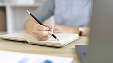 Not defterine not alan Asyalı kadın evde dizüstü bilgisayarda çalışırken, görüntülü sohbet, online iletişim, Evde kal, Yeni Normal, Mesafeli Öğrenme