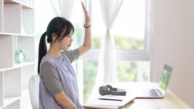 Genç Asyalı kadınlar video sohbetleri yoluyla arkadaşlarını ve öğretmenlerini selamlıyor ve onları neşeli ifadelerle karşılıyor, İnternet iletişimi, Evde kal, Yeni Normal, VDO Çağrısı, Sosyal Mesafe, İnternet öğrenimi.