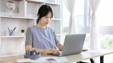 Çevrimiçi çalışan genç, arkadaşları ve öğretmenleriyle iletişim kurmak için bilgisayarını kullanıyor, sınıfta dizüstü bilgisayarlar ve veri grafikleri kullanıyor, çevrimiçi iletişim, sosyal uzaklık.