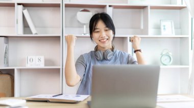 Neşeli, şaşırmış ya da şok olmuş Asyalı kadın kollarını kaldırdı çünkü iyi bir iş çıkardı patron ona büyük bir ikramiye verdi onu çok mutlu etti, elinizi kaldırın, gülümseyin ve başarı için bağırın..