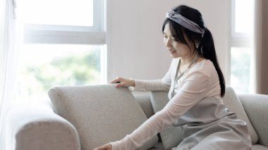 Genç ev hanımı kanepeyi temizliyor, oturma odasını temizliyor, evdeki büyük temizlik mikropları, kirleri ve derin lekeleri temizliyor, ev hanımı temizliyor, evini temiz tutuyor, evdeki hijyeni temizliyor.. 