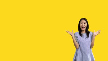 Asian woman acting shocked or surprised isolated on a white background,  Looking camera, Concept acts according to the emotions and feelings of excitement and shock, Yellow background, Copy space.