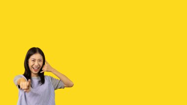 Call sign, Bright young asian woman inviting to call isolated on yellow background, Suggest to call or invite to apply for membership, Isolated on yellow background