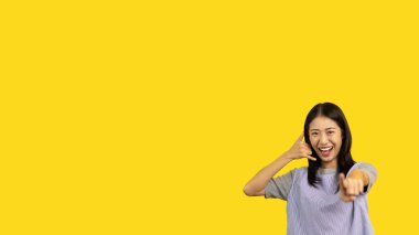 Call sign, Bright young asian woman inviting to call isolated on yellow background, Suggest to call or invite to apply for membership, Isolated on yellow background