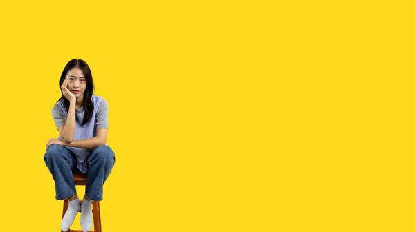 Asian Biracial Woman Sitting Wooden Chair Smiling Happily Yellow Background — Stockfoto