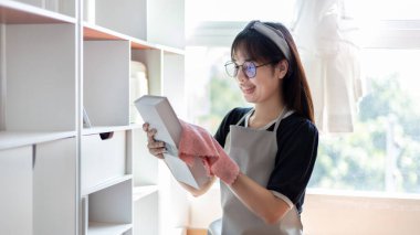 Housewives use towels to wipe things, tables, chairs, display cabinets and glass inside the house, Big cleaning, Housework, Daily routine ,Removes germs and dirt and deep stains, Spray alcohol, Clean up on weekends