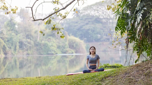 stock image Asian woman doing yoga in nature in the forest, Meditation and breathing exercises, Treat ADHD and train your mind to be calm, Healthy exercise, Mindfulness, Homeopathy, Park yoga.