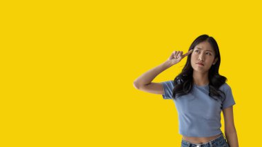 Young Asian woman thinking hard or planning to do something, Overthinking or worrying, Have a headache, Migraine, Stress, Free space for advertising or promoting products, Copy space, Enter text.