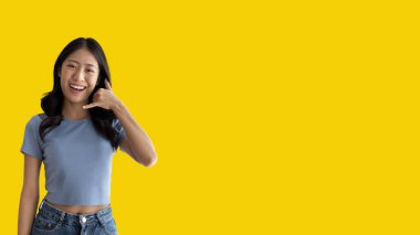 Call sign, Bright young asian woman inviting to call isolated on yellow background, Suggest to call or invite to apply for membership, Isolated on yellow background