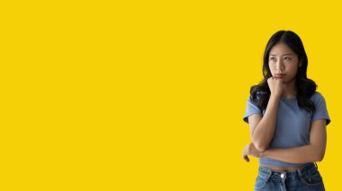 Young Asian woman thinking hard or planning to do something, Overthinking or worrying, Have a headache, Migraine, Stress, Free space for advertising or promoting products, Copy space, Enter text.