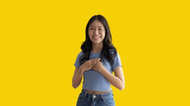 Asian woman smiling happily isolated on yellow background, Woman loves and rejoices herself, Contented, Pure love, Love myself, Proud of yourself, Self-made happiness, Optimism, Painting Therapy with a smile.
