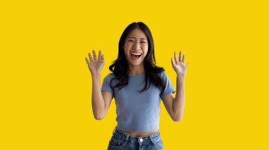 Asian woman posing extremely happy to win, Successful, Show extreme happiness, Very happy, yes, Lonely woman on yellow background.