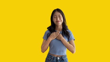 Asian woman smiling happily isolated on yellow background, Woman loves and rejoices herself, Contented, Pure love, Love myself, Proud of yourself, Self-made happiness, Optimism, Painting Therapy with a smile.