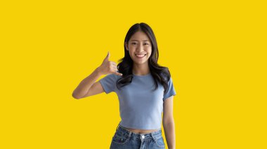 Call sign, Bright young asian woman inviting to call isolated on yellow background, Suggest to call or invite to apply for membership, Isolated on yellow background