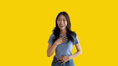 Asian woman laughing happily on yellow background, Happiness through laughter, Funny, Copy space, Portrait, Advertising text area, Isolated on yellow background.