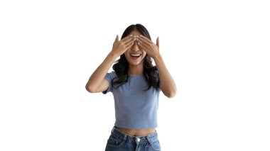 Yüzünü ve gözlerini yalıtılmış elleriyle kapatan genç bir kadın, korku ve meraklı gözlerle gözlerinizi kapayın, gizlice bakın, beyaz arka plan.