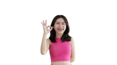 Young asian woman over yellow background doing ok sign with hands, OK symbol, Welcome, Agree, Join, Do as instructed, Follow orders, Acceptance of all conditions.