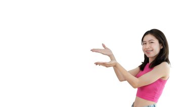 Asian woman with holding copyspace imaginary on the palm to insert an ad, Showing copyspace pointing, Showing her hand to present something on yellow background.