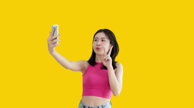 Waving hand in hi, Asian woman smiling friendly greeting, Hello,nice to meet you,say hi, Say hi and greet you, Welcome new people Join a multicultural team, Goodbye, Isolated on yellow background.