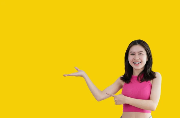 Asian Woman Holding Copyspace Imaginary Palm Insert Showing Copyspace Pointing — Stockfoto