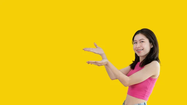 Asian Woman Holding Copyspace Imaginary Palm Insert Showing Copyspace Pointing — Stockfoto