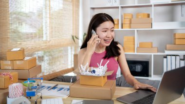 Çevrimiçi alışveriş şirketi sahibi telefonda teslimat adresi ve teslimat çizelgesini, KOBİ girişimcisinin online alışverişini, paketleme kutusunu, çevrimiçi satışı ve serbest çalışma programını yazmak için bir müşteriyle konuşuyor..