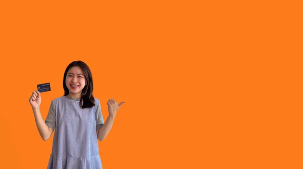 Asian Woman Holding Credit Card Thumbs Orange Background Suggest Demonstrate — Stock Photo, Image