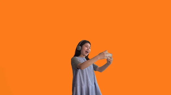 Asian Woman Playing Games Mobile Phone Wearing Headphones Having Fun — Stock Photo, Image