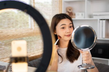 Sosyal medyadan etkilenen güzel kadınlar makyaj yapmayı ve makyaj yapmayı öğretiyor, kamera önünde video canlı yayını, internet üzerinden güzellik blogcuları kavramını kaydediyorlar..