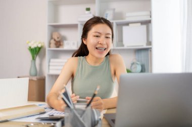 Asyalı kız öğrencilerin sohbet etmesi ya da bilgi alışverişinde bulunması dizüstü bilgisayar video çağrısı, kablosuz eğitim sistemi, öğretmenler ve sınıf arkadaşlarıyla konuşmaları, çevrimiçi öğrenme, kendi evinizde eğitim.
