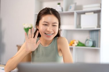 Asyalı kız öğrencilerin sohbet etmesi ya da bilgi alışverişinde bulunması dizüstü bilgisayar video çağrısı, kablosuz eğitim sistemi, öğretmenler ve sınıf arkadaşlarıyla konuşmaları, çevrimiçi öğrenme, kendi evinizde eğitim.