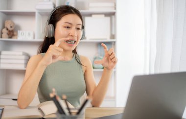 Asyalı kız öğrencilerin sohbet etmesi ya da bilgi alışverişinde bulunması dizüstü bilgisayar video çağrısı, kablosuz eğitim sistemi, öğretmenler ve sınıf arkadaşlarıyla konuşmaları, çevrimiçi öğrenme, kendi evinizde eğitim.