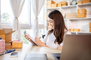 Çevrimiçi satış işlerinde, küçük işletme sahipleri envanterleri kontrol ederek müşterilere uygun teslimat için hazırlıyorlar, Evden çalışmak: E-ticaret operasyonlarını yönetmek. 