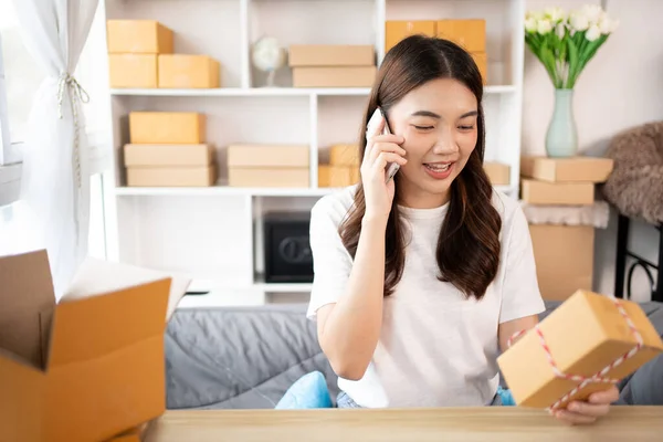 stock image Online shopping business owner is talking on the phone with a customer to jot down the delivery address and delivery schedule, SME entrepreneur online shopping, Packaging box Sell online, Work freelance.