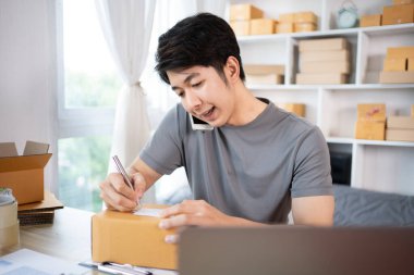 İçişleri Bakanlığı 'nda sevkiyat için Müşteri Ayrıntıları Yazan, Paketleme Kutusu ve Verimli Taşımacılık, E-Ticaret ve Çevrimiçi Satış Konsepti için Müşteri Bilgileri Yazan Adam.