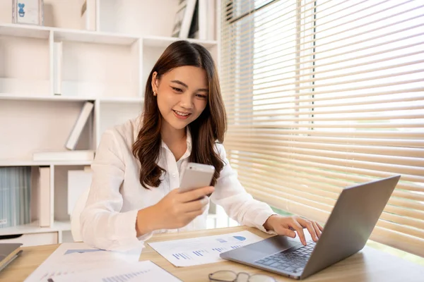 stock image Young female college students talk on the phone and do homework at the same time, Happy home life, Work from home.