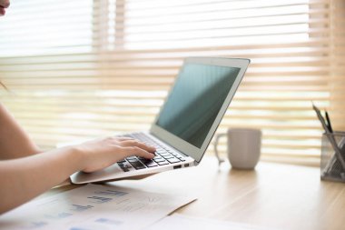 Woman using laptop to work or do homework at home with smiling face in her office, Creating happiness at work with a smile, Live performance or vdo call with laptop, Work from home.