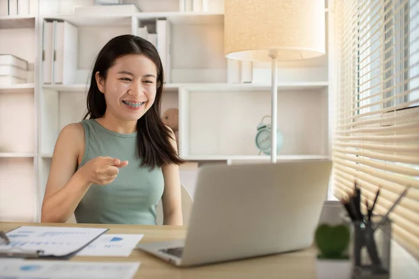 Young woman Working from Home, Video Call with Customer in Office, Remote Business Communication, Telecommuting Professional, Virtual Video Call with Office Customer, Work from Home Concept.