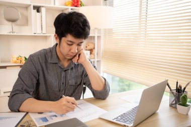 Genç işadamı veri grafiklerini analiz eder ve özenle kişisel ofisinde çalışır. Ofiste çalışanlar, masasında çalışan işadamları..