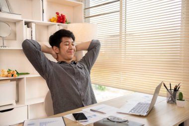 Genç adam işten sonra dinleniyor, gevşiyor, kendini esnetiyor..