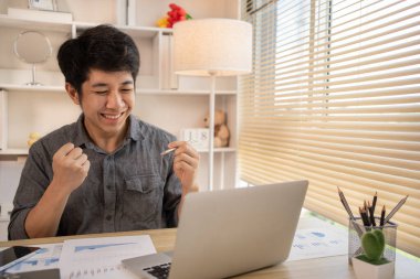 Son derece mutlu, gülümseyen genç adam sınavları geçmekten ya da iyi notlardan memnun ya da şaşırmış başarılı olmak seni mutlu ediyor, gülümsüyor ve başarı için bağırıyor, kazanan hareketi yapıyor, evet..