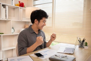 Son derece mutlu, gülümseyen genç adam sınavları geçmekten ya da iyi notlardan memnun ya da şaşırmış başarılı olmak seni mutlu ediyor, gülümsüyor ve başarı için bağırıyor, kazanan hareketi yapıyor, evet..